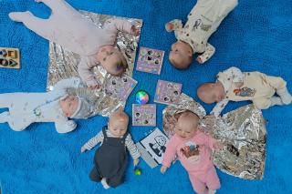 Babies laid in a circle on a mat at a Baby Week session