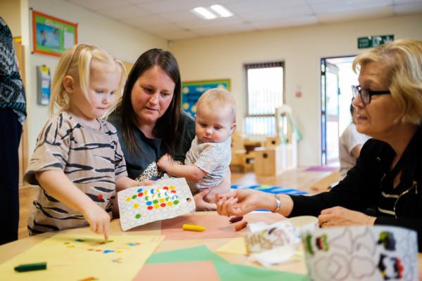 Two adults and two children playing with stickers