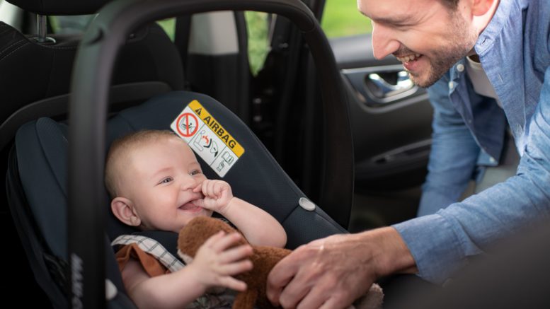 Dad putting baby in to car seat